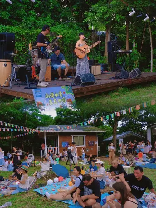 草坪音乐会正式开始了大家铺上野餐垫席地而坐边用餐边欣赏轻快的旋律