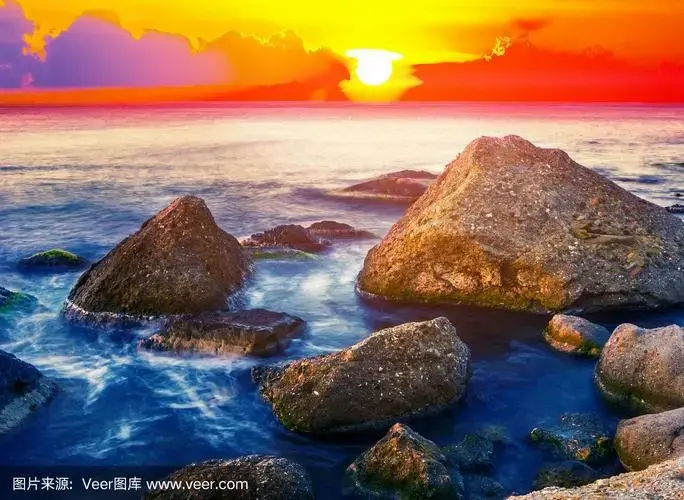 戏剧性的日出在海岸上,红色的天空在多石的海岸上